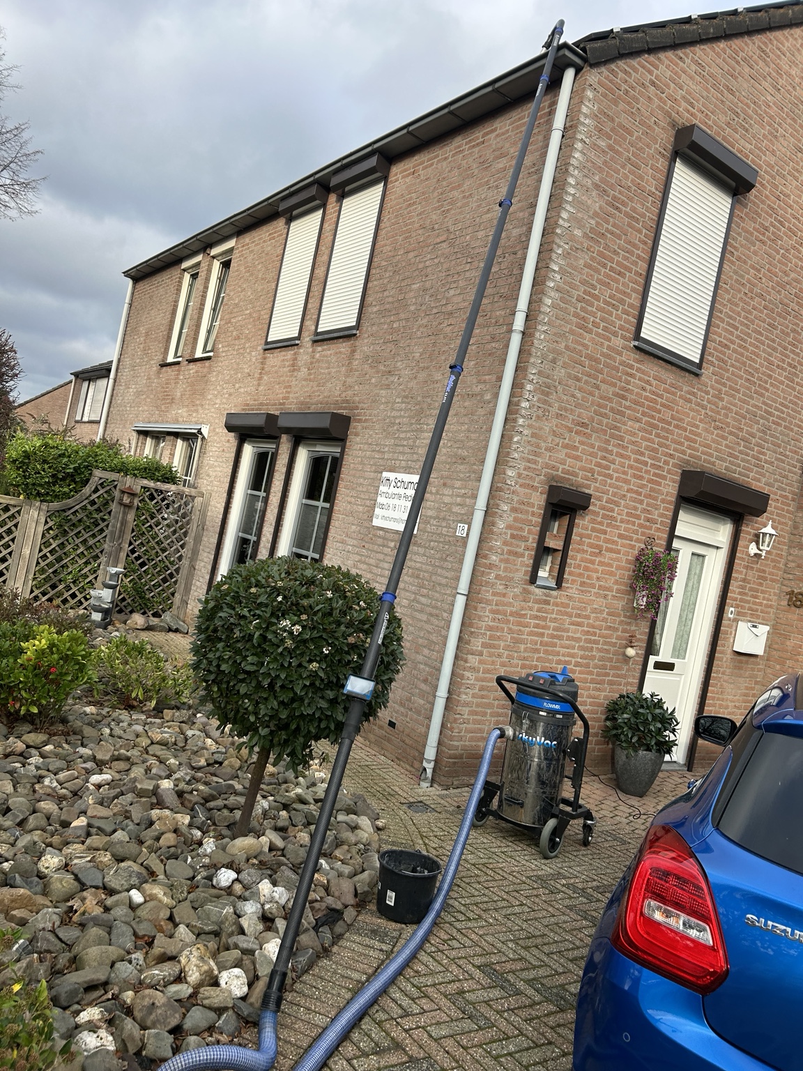 Telescoopstok en zuigunit bij een rijtjeshuis