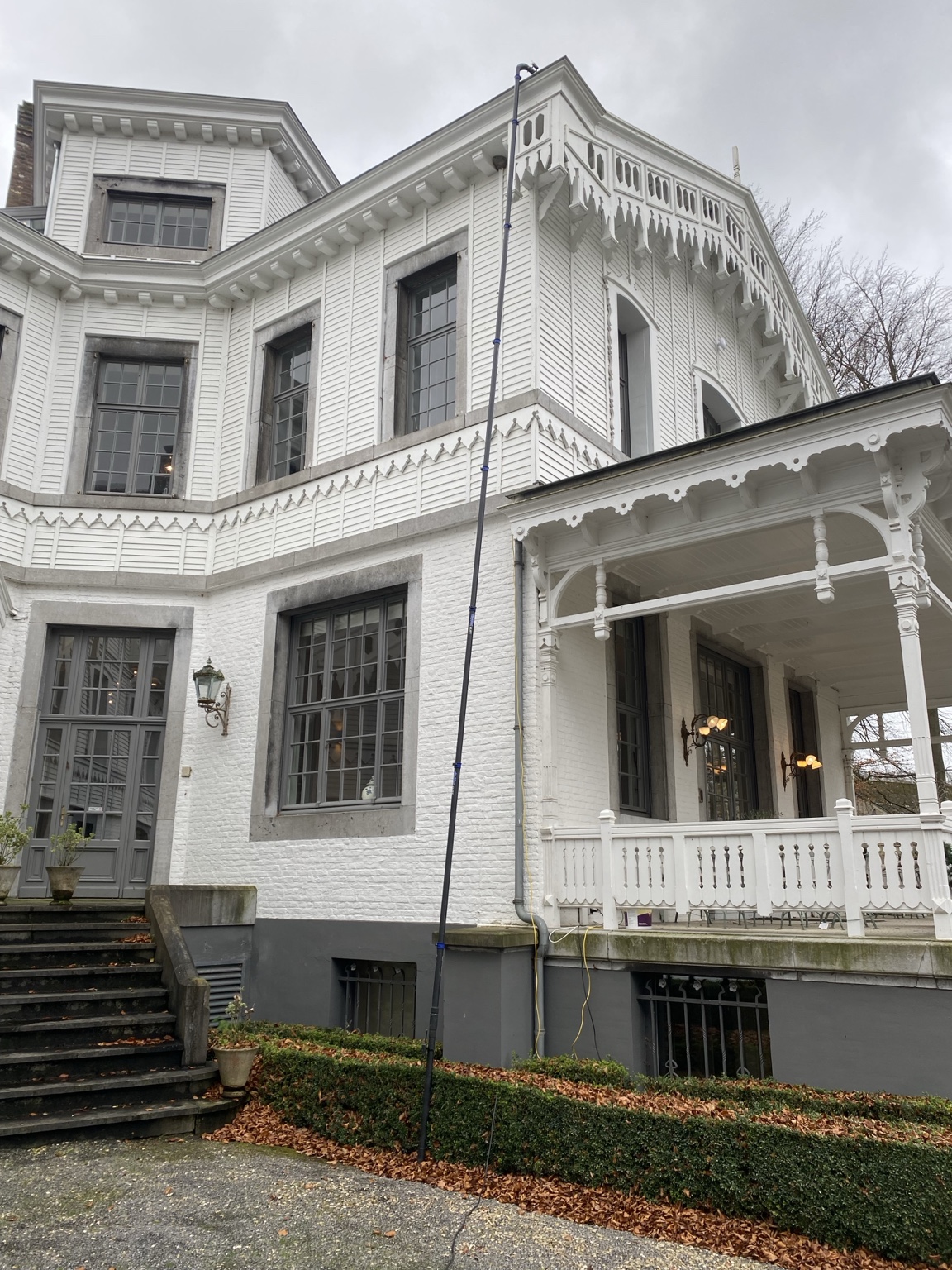 Telescoopstok bereikt de hoge dakgoot van een villa