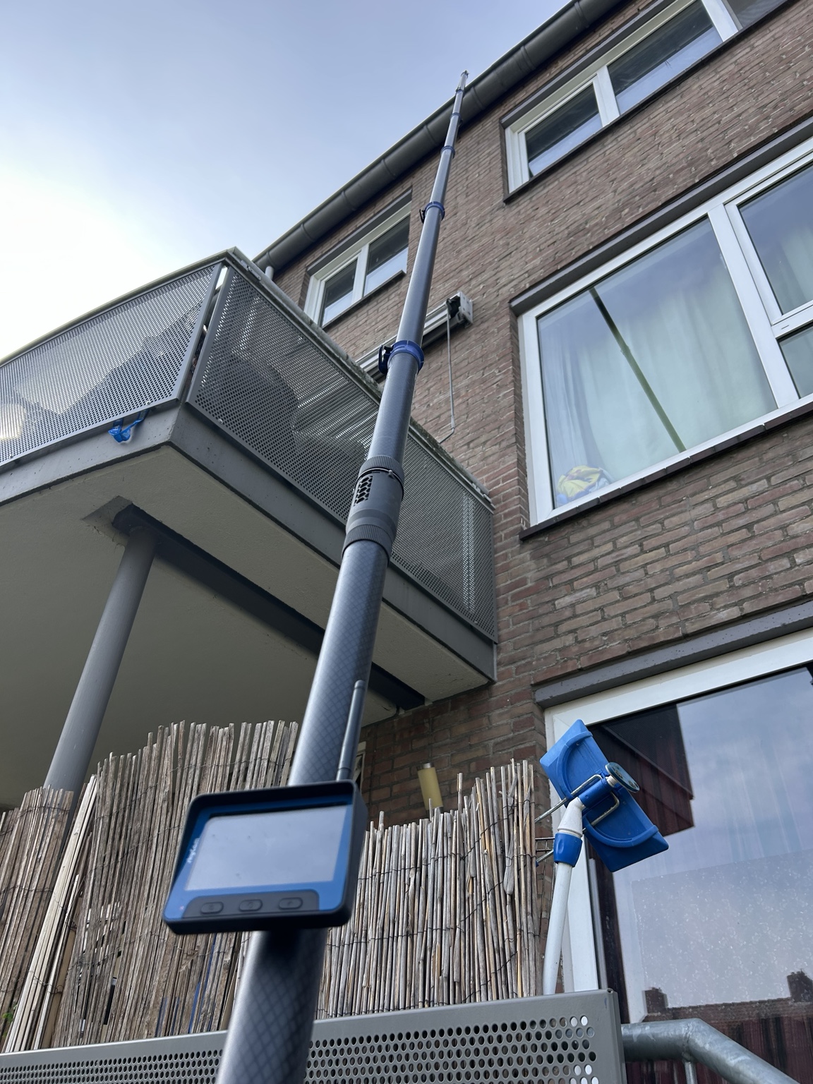 Telescoopstok bereikt de goot van een appartementencomplex